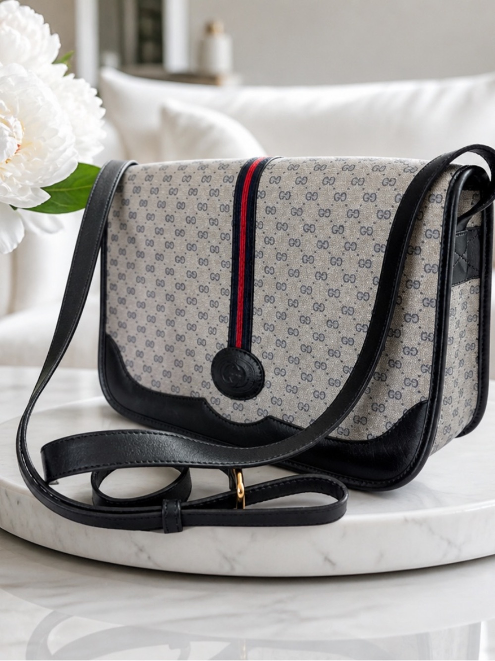 Gucci Grey GG Supreme crossbody with Black trim and red-blue stripe.